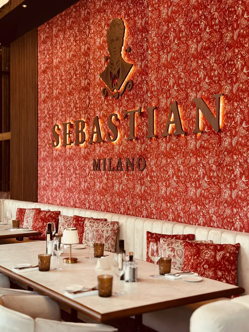 L'interno del Sebastian Café, col nome sulla parete di carta da parati rossa
