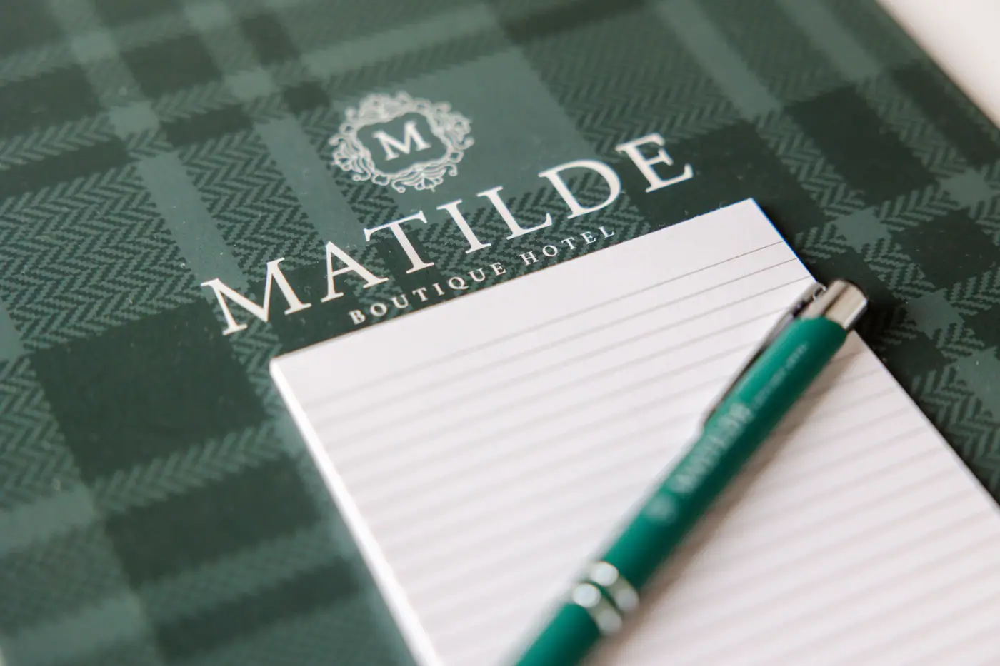 Il taccuino dell'hotel col tartan verde e la penna col nome Matilde